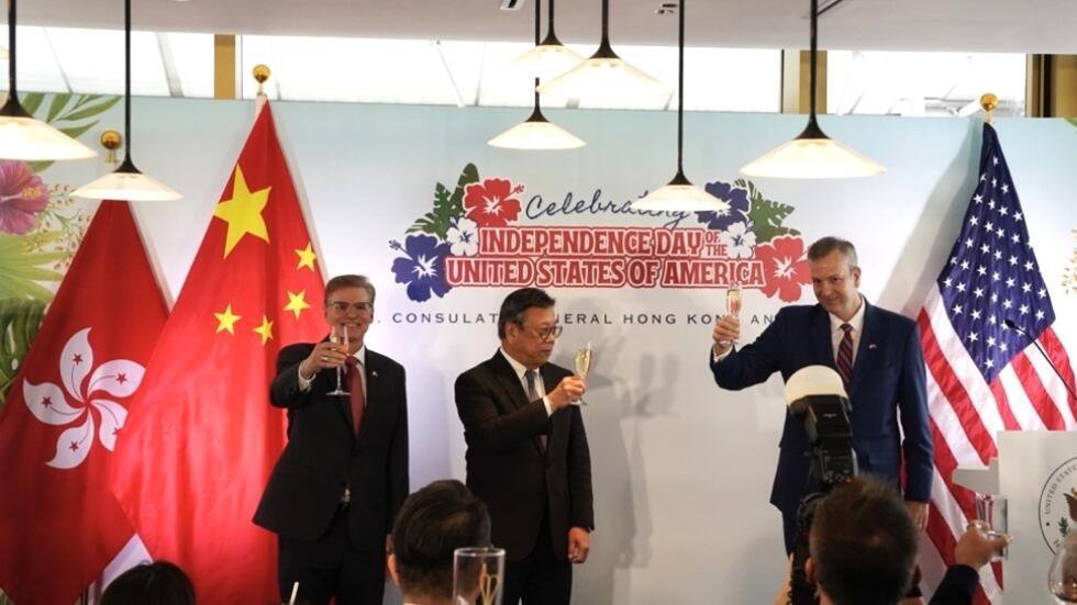27.6 港府一面提示学校出席美国国庆活动有国安风险，一方面派商经局长丘应桦(图中)出席美国国庆酒会。图右一是美国驻港总领事梅儒瑞。