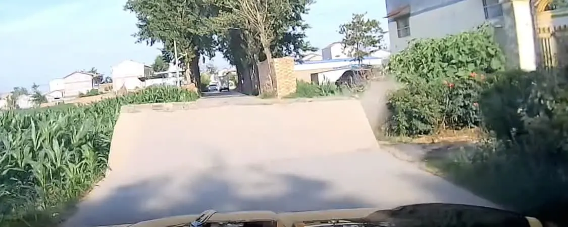 热炸了！小车突遇水泥路面爆裂拱起 急刹车躲过一劫