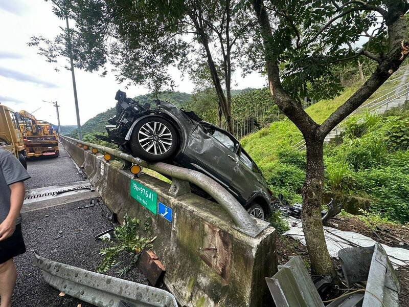 灰色休旅车追撞前方轿车后冲出护栏,最后倒挂在护栏上。(民众提供) 灰色休旅车追撞前方轿车后冲出护栏,最后倒挂在护栏上。(民众提供)