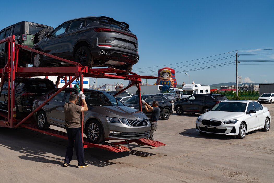 在满洲里二手车出口基地,工人们正在装载准备出口到俄罗斯的二手车。
