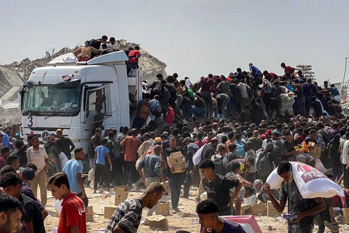 在加沙南部的汗尤尼斯,人道救援卡车周边密密麻麻层层叠叠地挤满了争先恐后抢掠粮食的饥民。(法新社) 在加沙南部的汗尤尼斯,人道救援卡车周边密密麻麻层层叠叠地挤满了争先恐后抢掠粮食的饥民。(法新社)