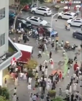 小貨車突然加速，直接衝上騎樓，撞擊人群後才停在奶茶店門口，有人倒地呻吟，有人被壓在車下，場面混亂驚悚。（圖／翻攝微博）