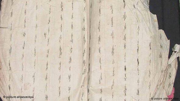 两页打开的纸上 写着形似柳叶的女书文字