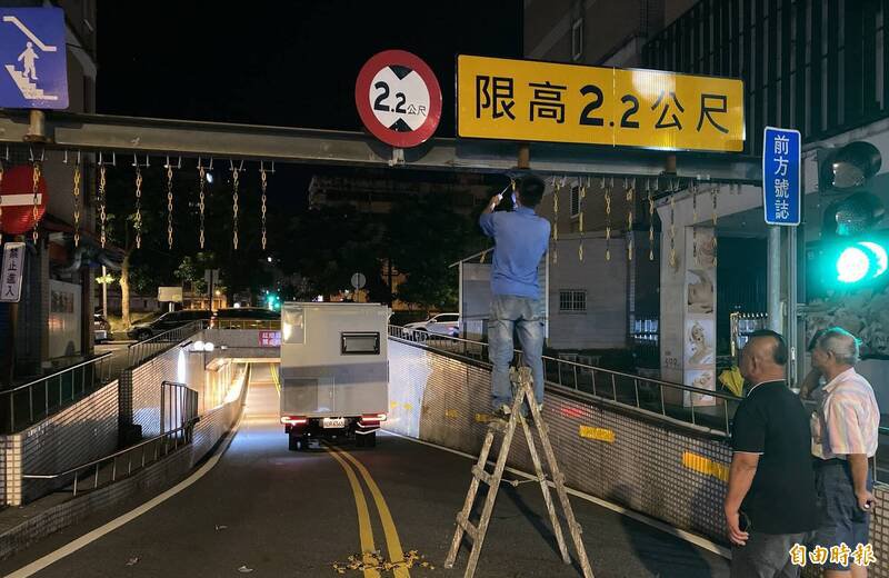 罗东镇公所派员切掉限高架上活动式铁链，协助露营车脱困。（图由张添财提供）