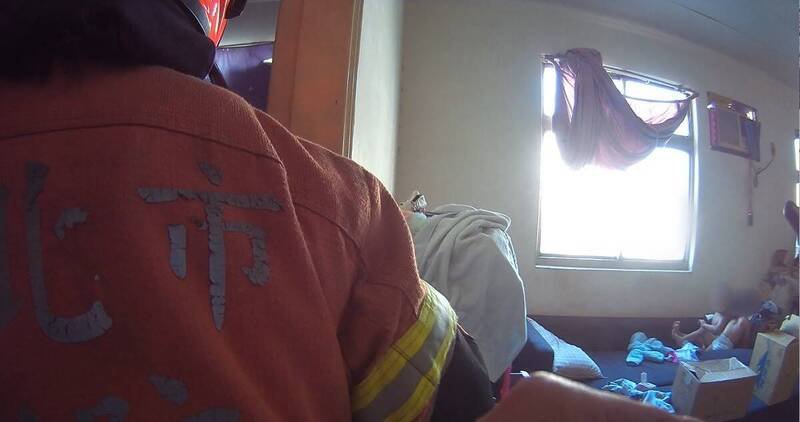 新北市树林一对幼儿赫见挂在铁窗上，随时恐坠落，警方、消防赶抵破门，进屋救援。（记者吴仁捷翻摄）