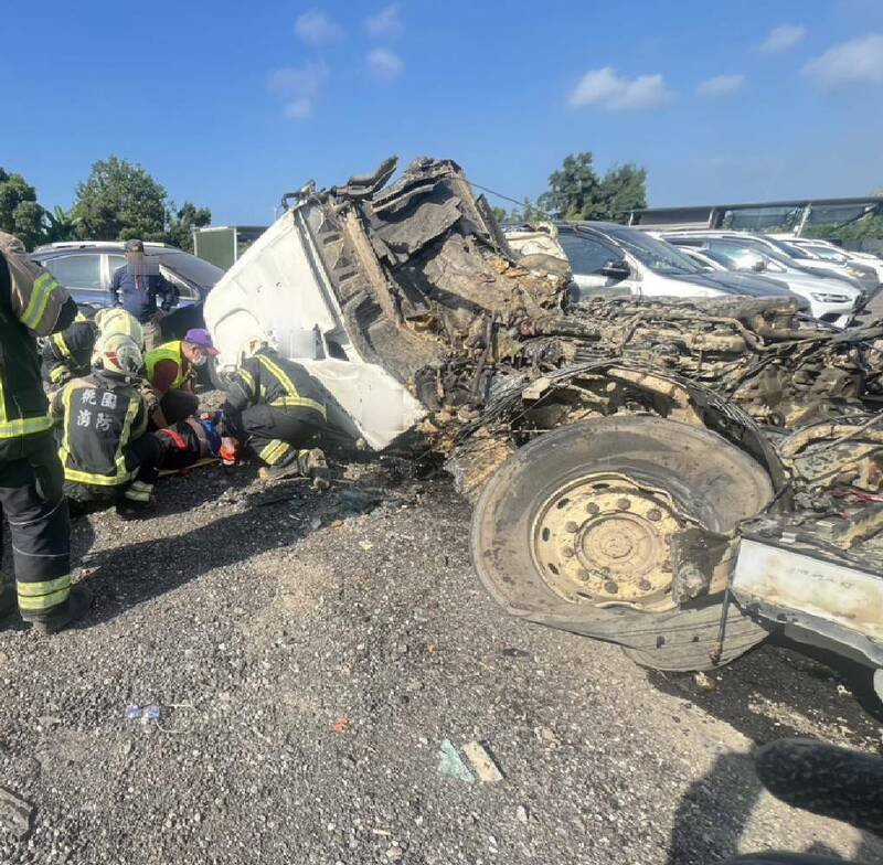 桃园市消防局大三大队大园分队救护人员抢救受困车头内的张姓驾驶。（记者余瑞仁翻摄）