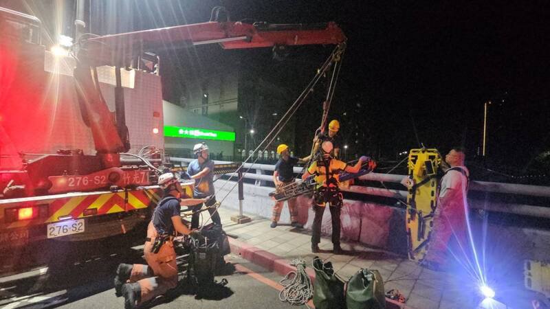 因正值枯水期，老妇人跳桥后头部受重击，经救援人员利用担架吊载到路面，老妇人已明显OHCA，送国泰医院抢救。（记者洪美秀翻摄）