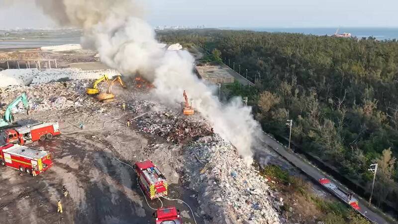 台南城西掩埋场下午突起火，浓烟直窜天际，消防出动15车29人灌救，环保局调派怪手协助清除堆置物，成功局限火势。（南市消防局提供）