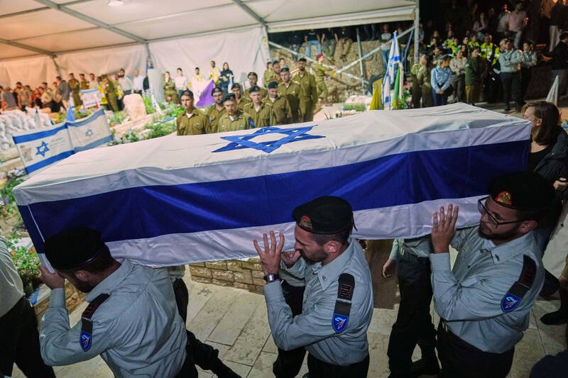 10月15日，以色列士兵在耶路撒冷赫茨尔山（Mt. Herzl）军事公墓，为遇害人质佩雷茨上尉（Captain Daniel Peretz）举行葬礼，抬棺送行。（美联社）
