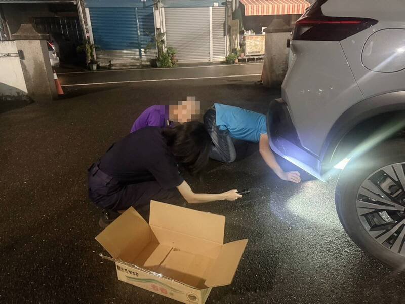 警方帮助民众从车底救出穿山甲。（警方提供）