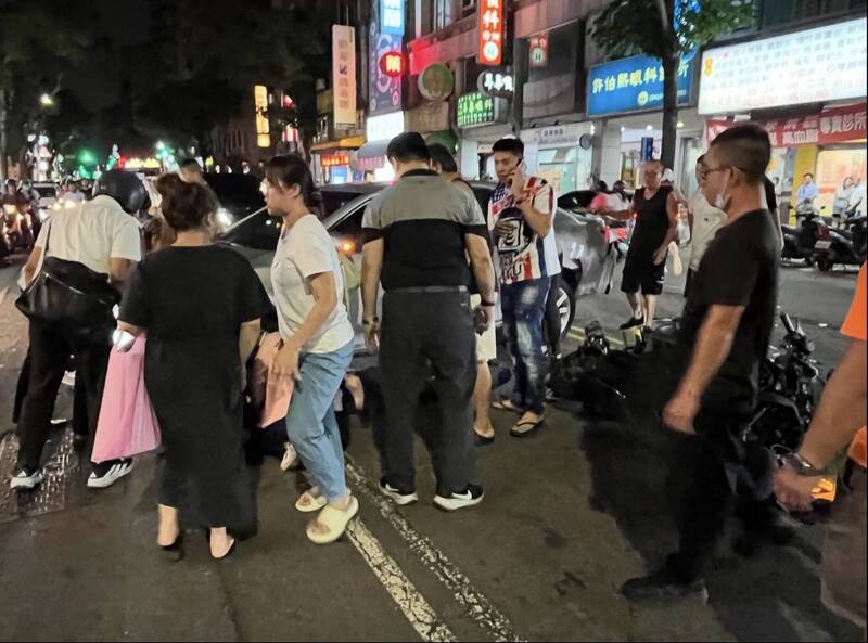 民众看到机车骑士卷入车底，赶紧上前搭救，抬车救人，协助骑士脱困。（翻摄自threads）