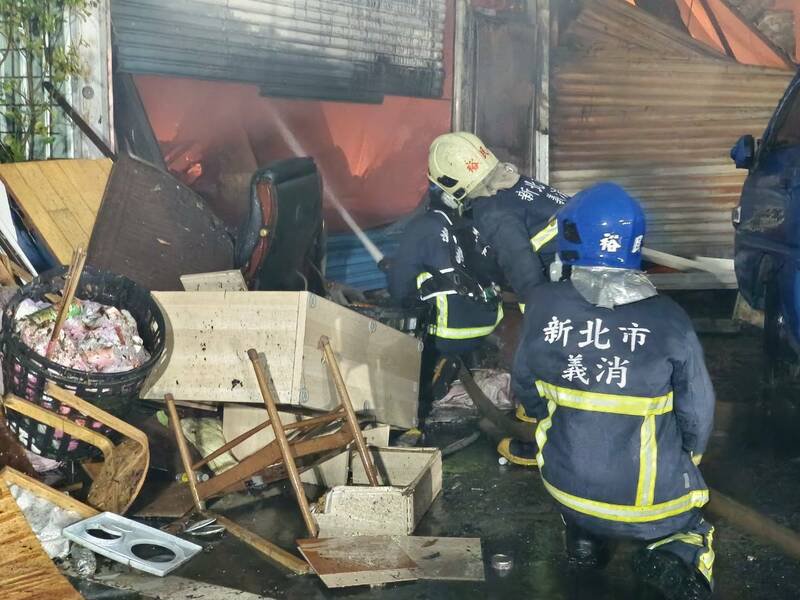 消防破门寻找火点，从外部射水、阻隔延烧。（警方提供）