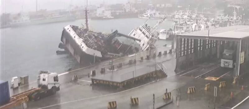 停靠在基隆港东15号码头的驳船「宏略8号」，今天疑进水导致船头沉没，且船身向右倾斜船尾翘起。港务公司已在周边围起拦油索，避免污染。（图为民众提供）