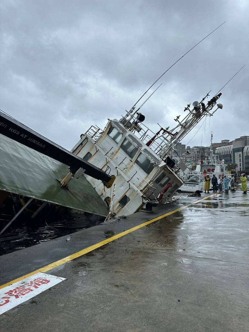 停靠在基隆港东15号码头的驳船「宏略8号」，今天疑进水导致船头沉没，且船身向右倾斜船尾翘起。港务公司已在周边围起拦油索，避免污染。（图为民众提供）
