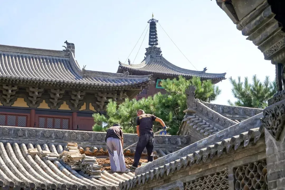 2023年，山西大同，工人在修缮华严寺的瓦顶。（图/视觉中国）