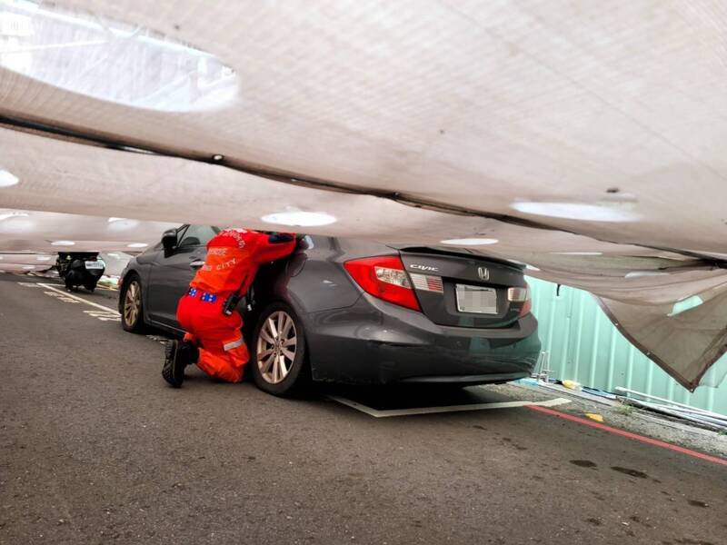 倒塌鹰架压到汽车，消防人员协助驾驶脱困。（民众提供）