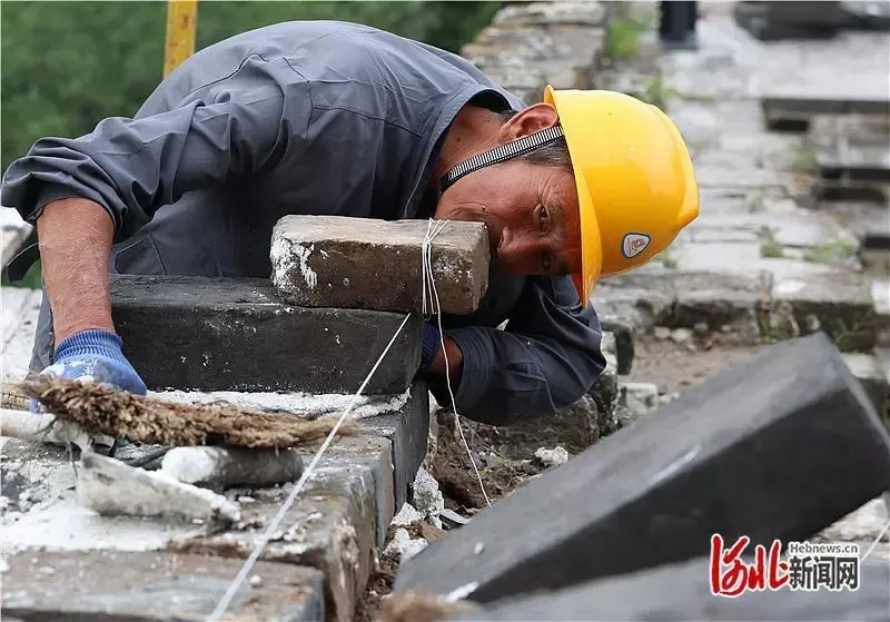老外游长城遇无人机吊运材料纷纷惊叹，还现学铺青砖体验“修长城”