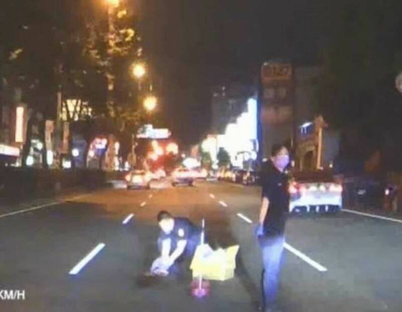 员警将受伤的流浪猫装入纸箱。（图由警方提供）