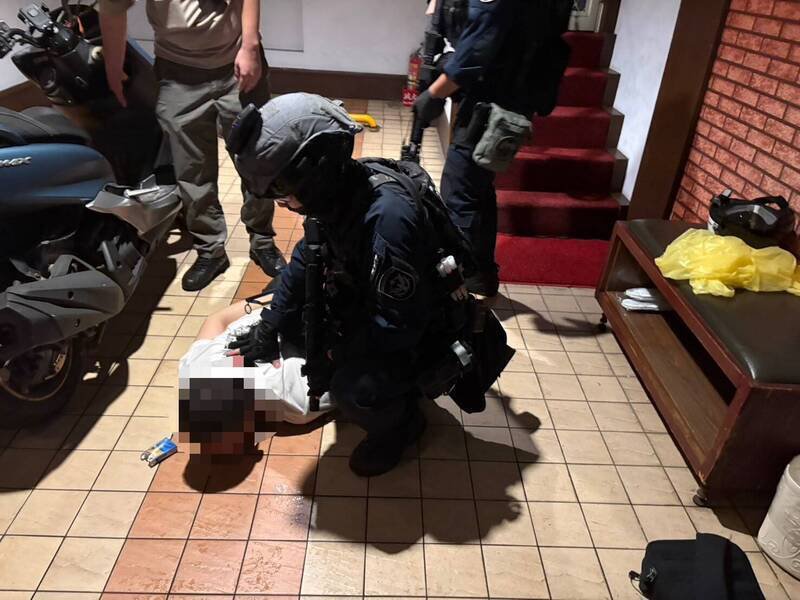 警方在汽旅内将犯嫌压制在地。（记者徐圣伦翻摄）