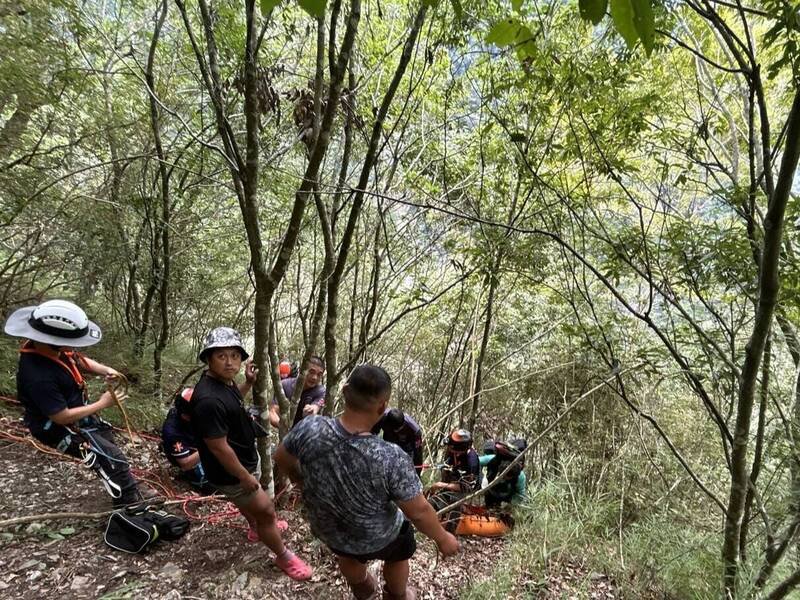 玉山八通关高山协作不慎坠落50公尺深谷，搜救人员以绳索搭配担架，缓步拉上步道后紧急送医治疗。（南投县消防局提供）
