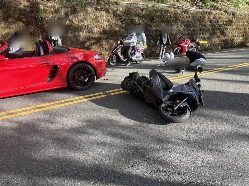 机车骑士从合欢山骑车下清境途中，追撞前方敞篷跑车，机车倒向对向车道，人摔落躺在路上。（仁爱警方提供）