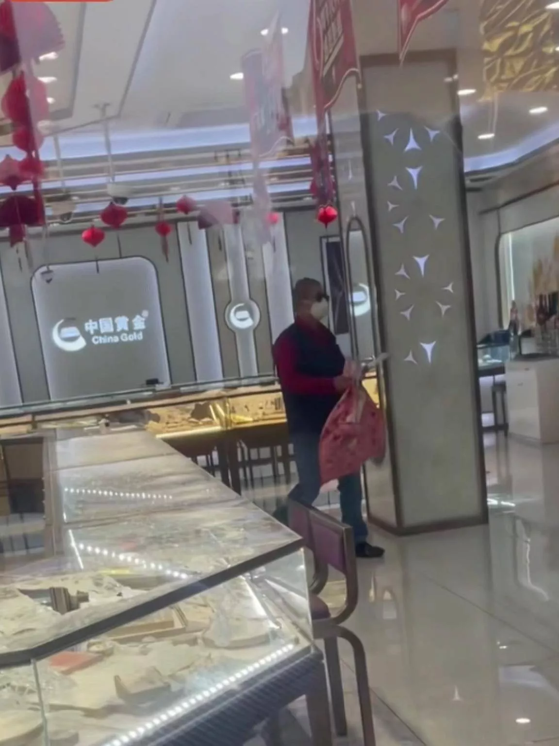 男子拿口袋抢劫上海一金店,多人在店外围观