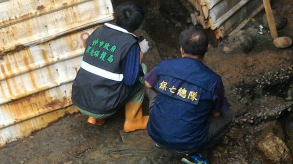 趁著雨势暂缓，警察与环保人员爬入排水涵洞内，采集电镀工厂排放的废水。（记者张瑞桢翻摄）