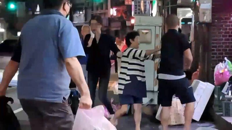 女店员被殴后，用右手扶著下巴。（记者吴升儒翻摄）