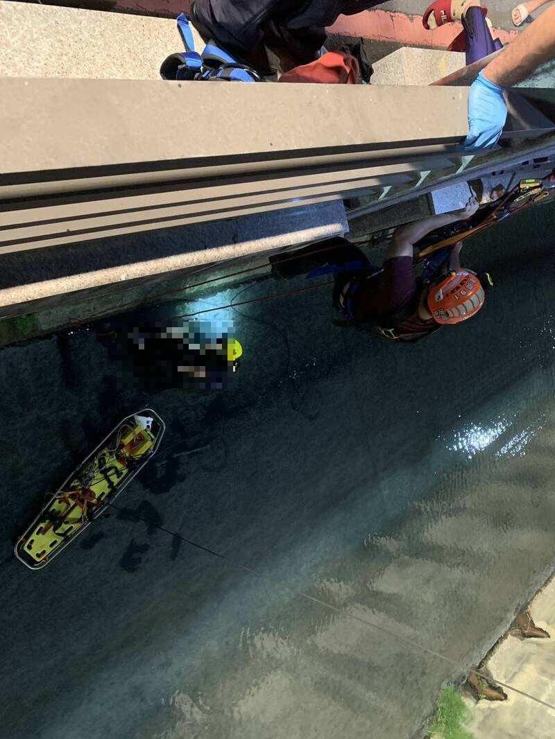 消防人员下到台南北区柴头港溪，救援坠落溪底的受伤女子。（民众提供）