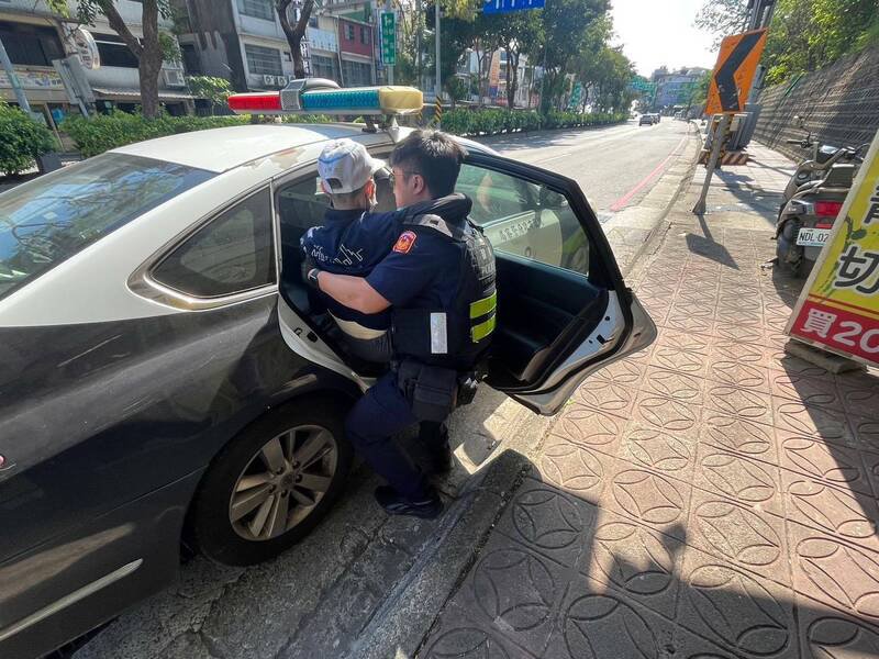 吴姓老翁负气离家跌坐路边，由于行动不便，一时无法自行起身，警方接获通报赶抵现场，耐心搀扶老翁起身，更一把将老翁「公主抱」安置上车。（警方提供）