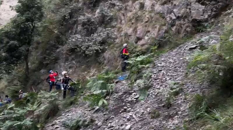 45李姓男子昨（9日）攀登郡大山失踪，搜救员在陡峭山壁搜寻。（南投县消防局提供提供）