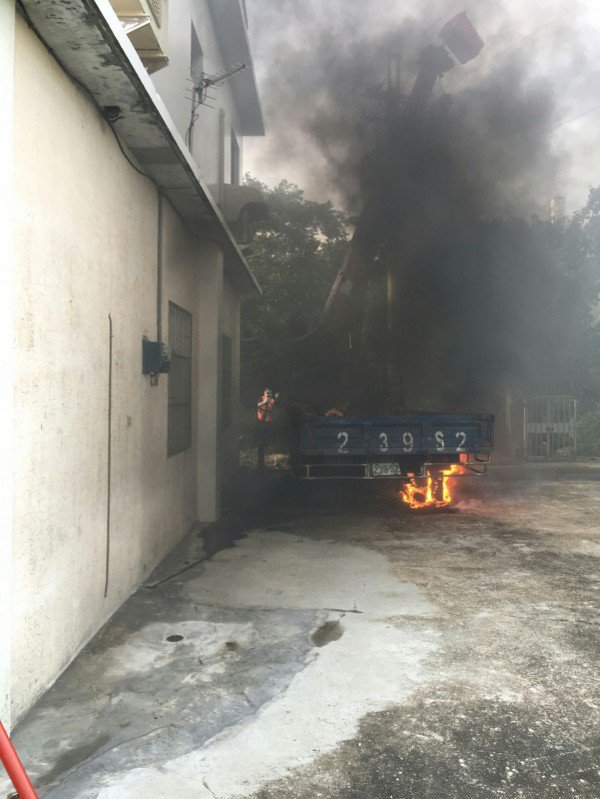 新竹县竹北市联兴三街受一民宅委托的葬仪社今天下午雇用工人协助修剪住家旁的树木，不料却发现工人疑因误触树旁的高压电，遭电毙倒卧地上，身体焦黑已无生命征象，并引发一辆汽车火警。（记者廖雪茹翻摄）