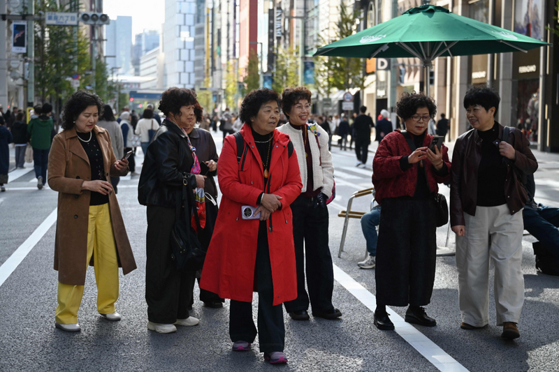 图为今年11月，一群中国游客在东京银座逛街画面。（法新社）