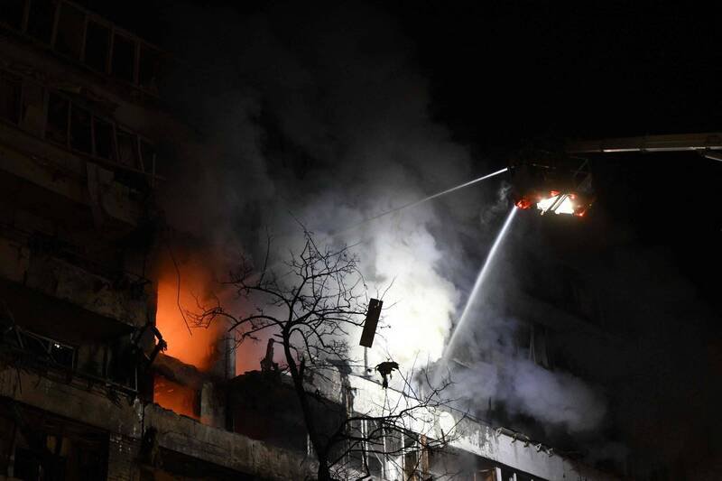 乌克兰首都基辅25日凌晨遭俄军深夜飞弹与无人机袭击，住宅大楼起火冒烟，消防员在瓦砾间持续灌救。（法新社）