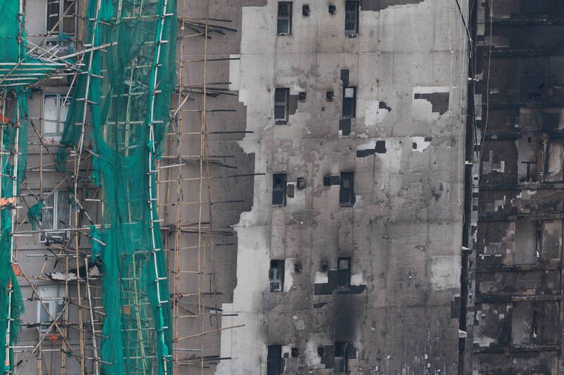 香港大埔宏福苑火灾现场28日仍可见被烧毁的外墙与竹棚。这场恶火已造成至少128人死亡。（欧新社）