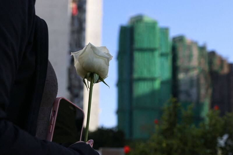 民众29日在宏福苑外献花悼念罹难者。（路透）