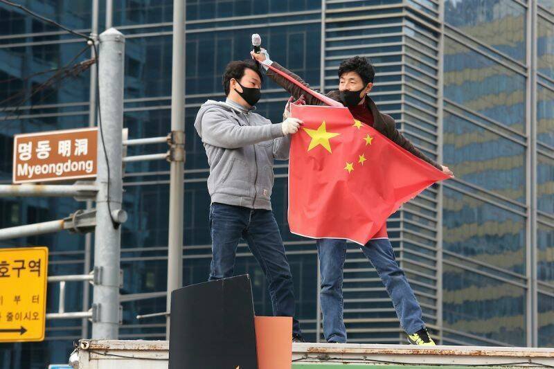 南韩保守派团体今年7月间在首尔明洞街头举行反中示威、撕毁中国五星旗，抗议中国干预选举。（美联社资料照）