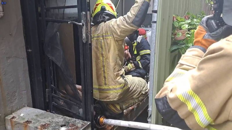 消防队员进入屋内进行抢救。（记者吴升儒翻摄）