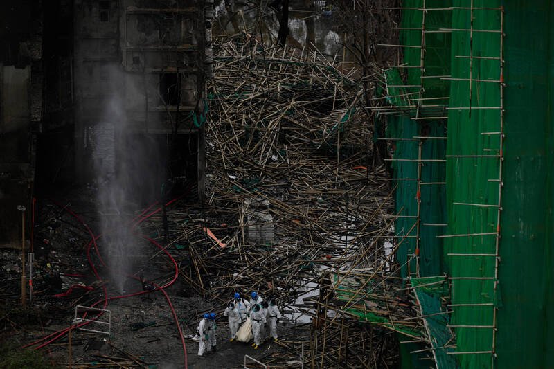 香港大埔宏福苑恶火酿惨重伤亡。右侧鹰架上悬挂的绿色防尘网，被认为是导致火势迅速蔓延的元凶。（美联社）