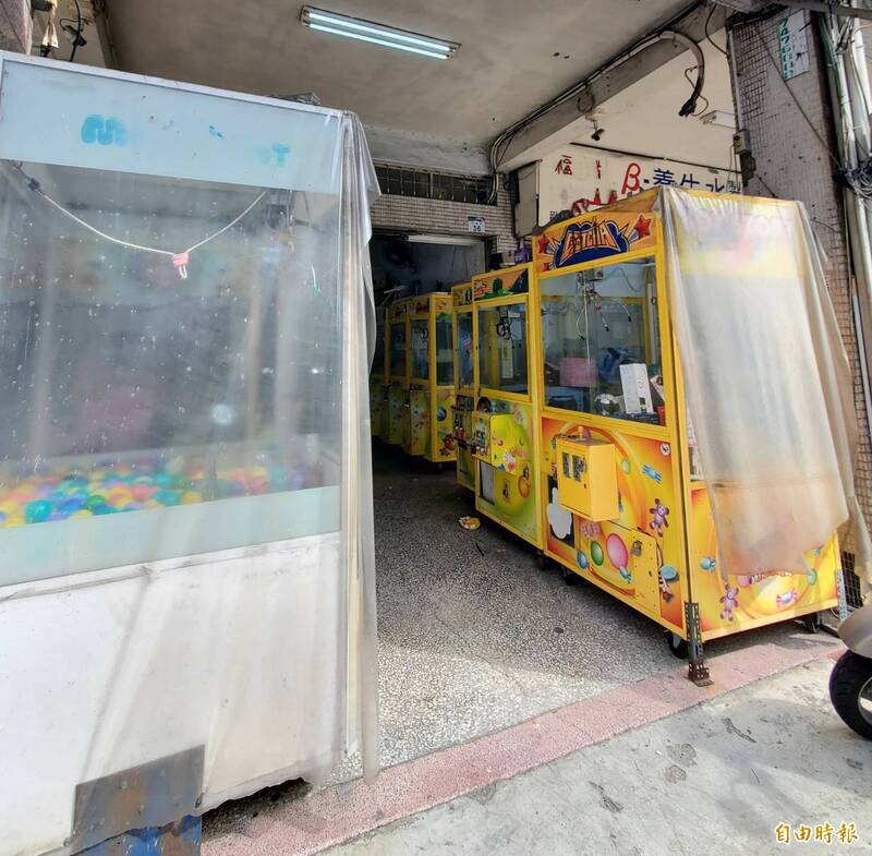 吕姓男子于案发地不到100公尺娃娃机店骑楼地，远距离观察命案现场。（记者陈文婵摄）