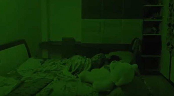 一位印度女孩在家中床上睡觉，身旁躺著一只大型泰迪熊绒毛娃娃，但睡到一半时娃娃突然动了起来。（图撷自YouTube/Peristiwa Baru）