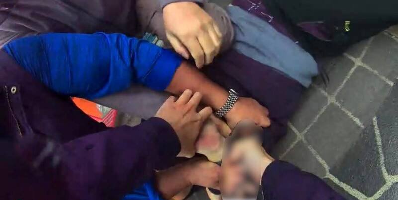 邱男被警方制伏在地，并上铐逮捕。（记者徐圣伦翻摄）