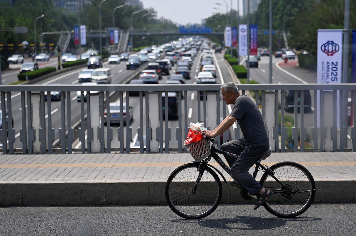 中国强制社保未解决养老保险体系存在的问题。一名老年人在北京一座立交桥上骑着脚踏车，摄于6月18日。 （法新社）