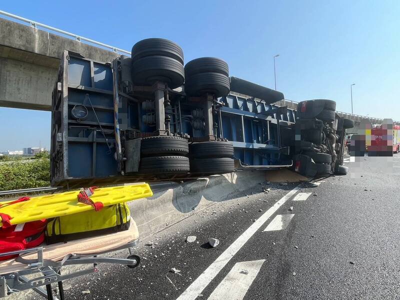 1辆营业半联结车从国1北向台南系统汇国8西行时，疑车速过快自撞护栏侧翻。（读者提供）