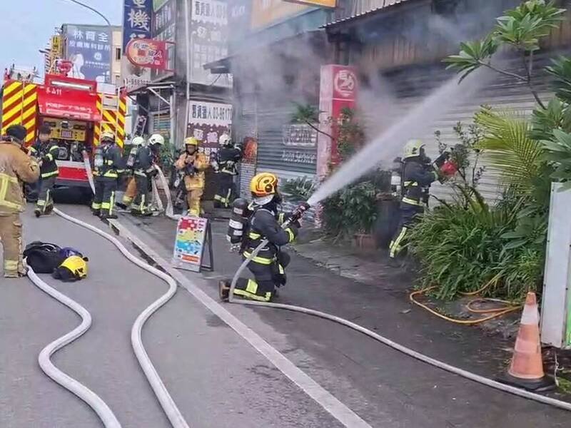 宜兰冬山一家汽修厂铁皮屋火警，消防人员到场射水灭火。（图由宜县消防局提供）