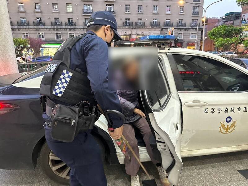 桃园吴姓阿嬷被车流吓到「抱电杆」，平镇警暖送她回家。（警方提供）