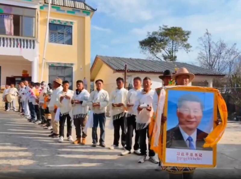 藏民身穿白衣排队,排头者手举「习近平总书记」的大幅相框。(取自萨格尔扎西SakarTashi X 影片) 藏民身穿白衣排队,排头者手举「习近平总书记」的大幅相框。(取自萨格尔扎西SakarTashi X 影片)