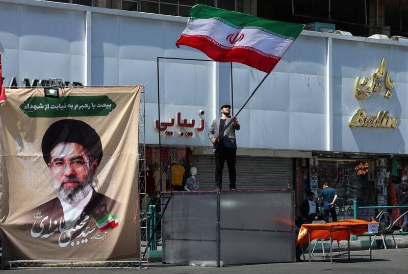 前美国中东谈判代表米勒认为，伊朗「手中的筹码」比美国更多。图为伊朗男子在德黑兰街头挥舞伊朗国旗。（欧新社）